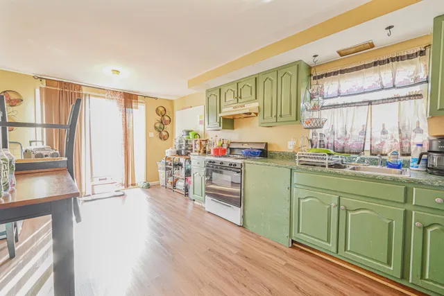 a kitchen with granite countertop a sink cabinets and wooden floor