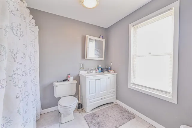 a bathroom with a granite countertop toilet a sink and a mirror
