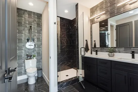 a bathroom with a double vanity sink toilet and shower