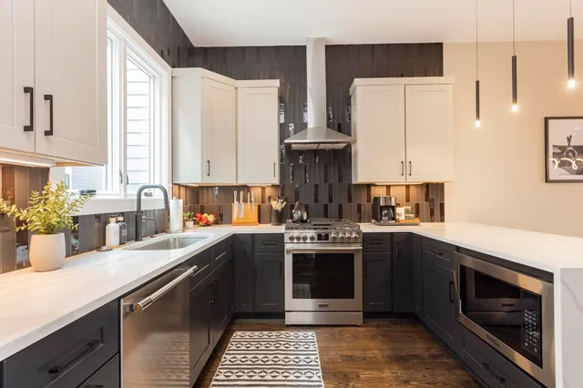 a kitchen with stainless steel appliances granite countertop a stove a sink and a refrigerator