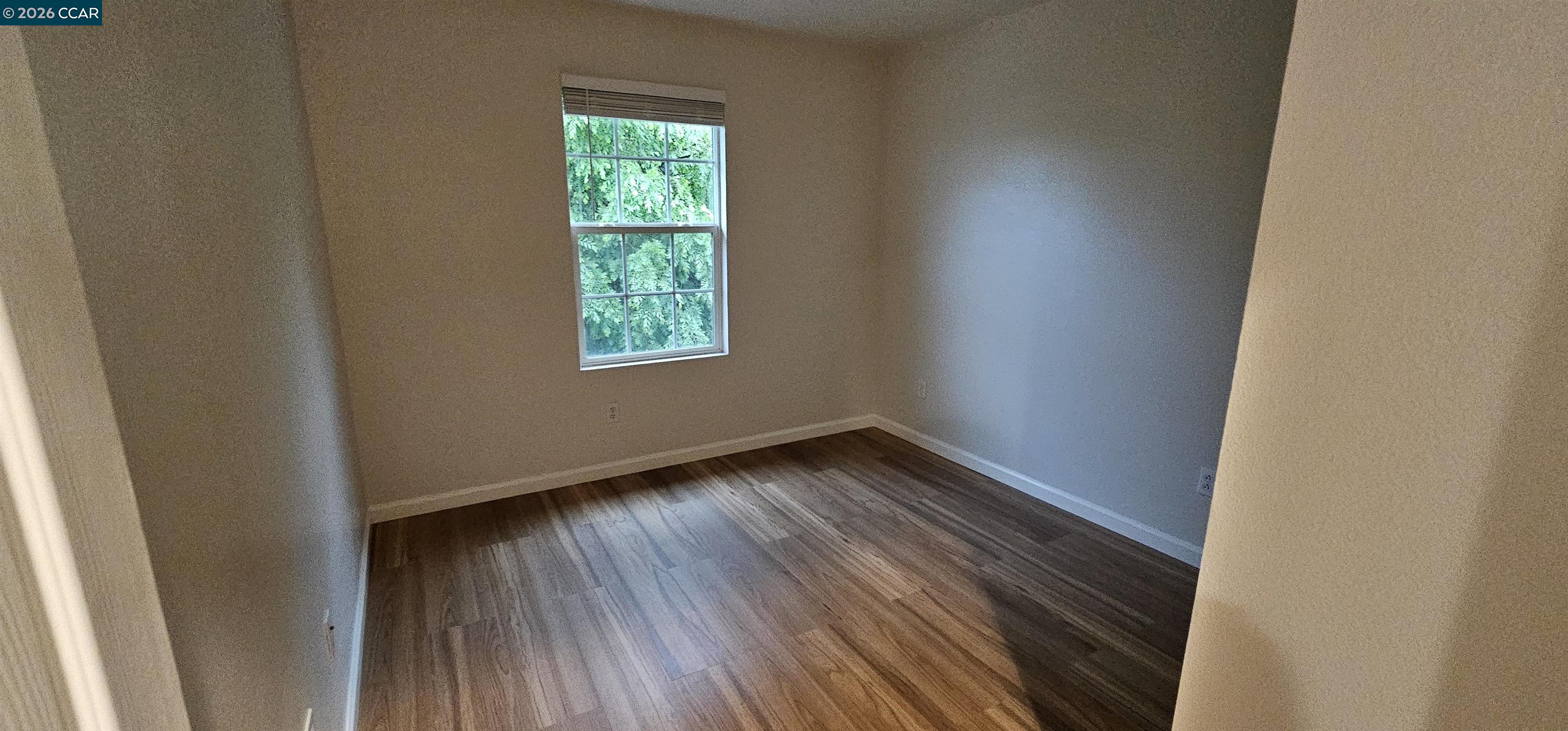 2297 Orleans Street Santa Rosa, CA 95403 - Photo 20 of 30 a view of an empty room with wooden floor and a window