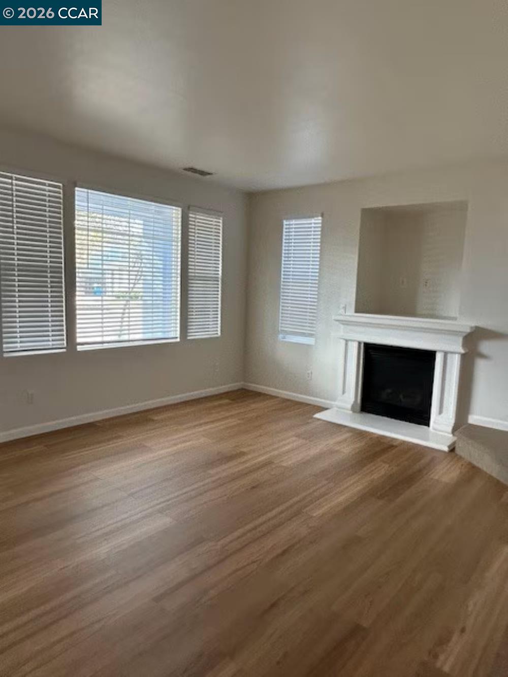 2297 Orleans Street Santa Rosa, CA 95403 - Photo 3 of 30 an empty room with wooden floor fireplace and windows