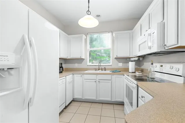 a kitchen with white cabinets and white appliances