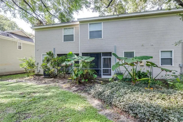 a front view of a house with garden and trees