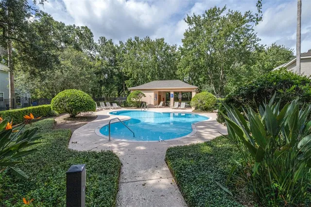 a front view of a house with garden and trees
