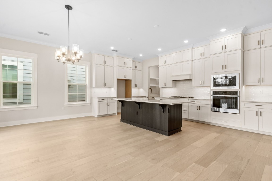 96606 Compass Point Drive Fernandina Beach, FL 32034 - Photo 13 of 88 a large kitchen with kitchen island granite countertop a stove top oven a sink a counter space and cabinets