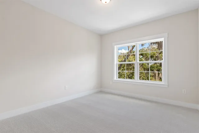 an aerial view of a house with a yard and trees all around