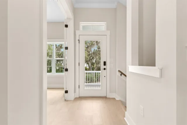 a large white kitchen with kitchen island a sink stainless steel appliances and a fireplace
