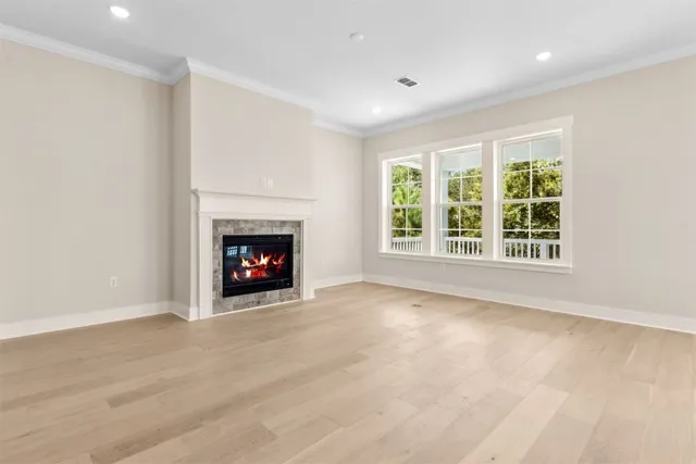 a view of an empty room with chandelier fan and a fireplace
