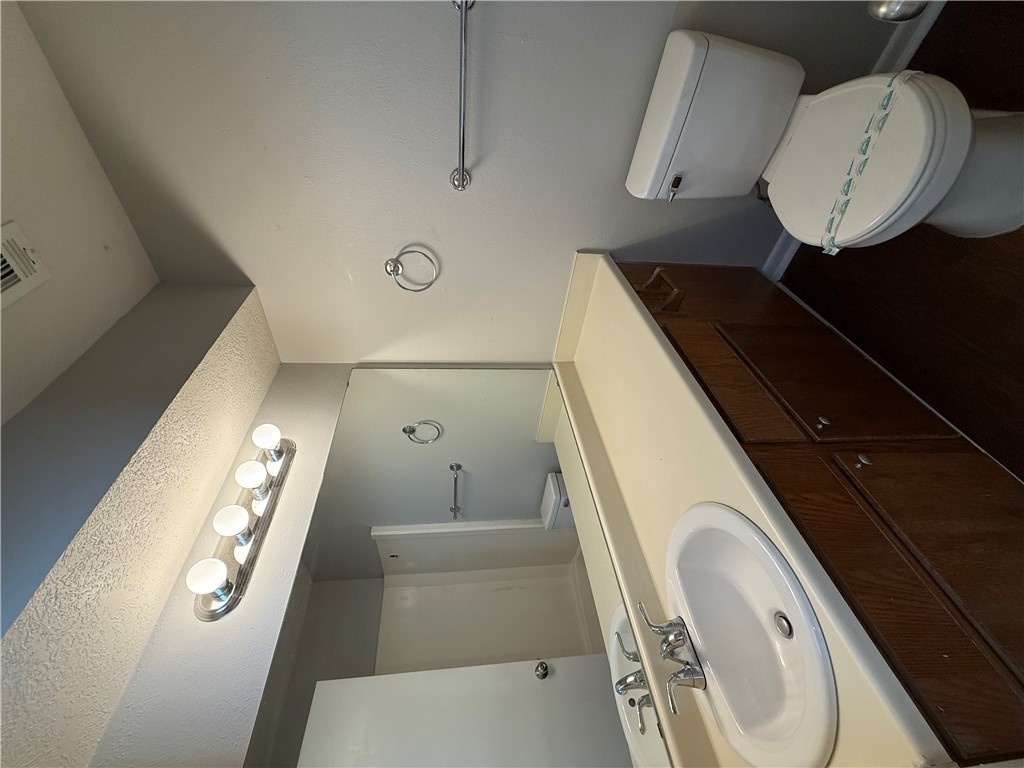 926 Spring Loop, Unit C College Station, TX 77840 - Photo 7 of 11 a bathroom with a sink a toilet and a mirror