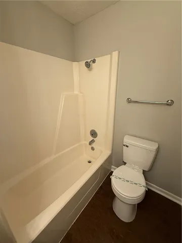 a white toilet sitting next to a bath tub