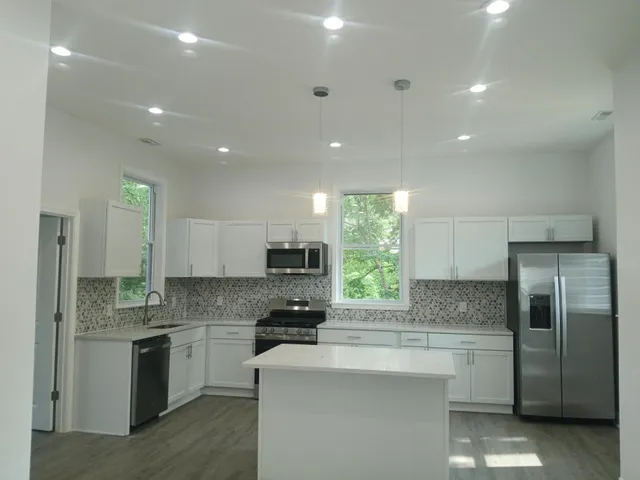 a kitchen with kitchen island a sink stainless steel appliances and window