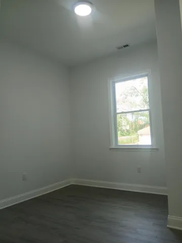 a view of an empty room with wooden floor