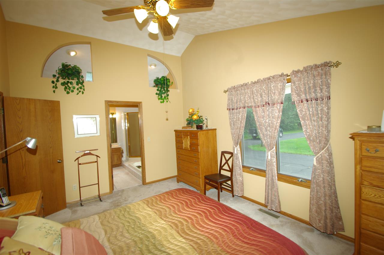 8638 Rote Road Rockford, IL 61107 - Photo 13 of 25 a bedroom with a bed and a chandelier