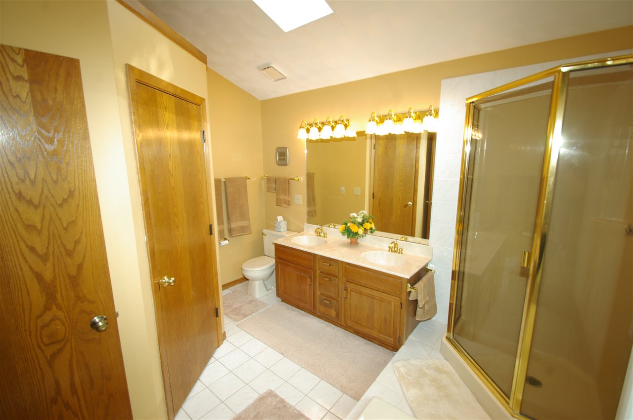 8638 Rote Road Rockford, IL 61107 - Photo 14 of 25 a large bathroom with a double vanity sink and mirror with shower