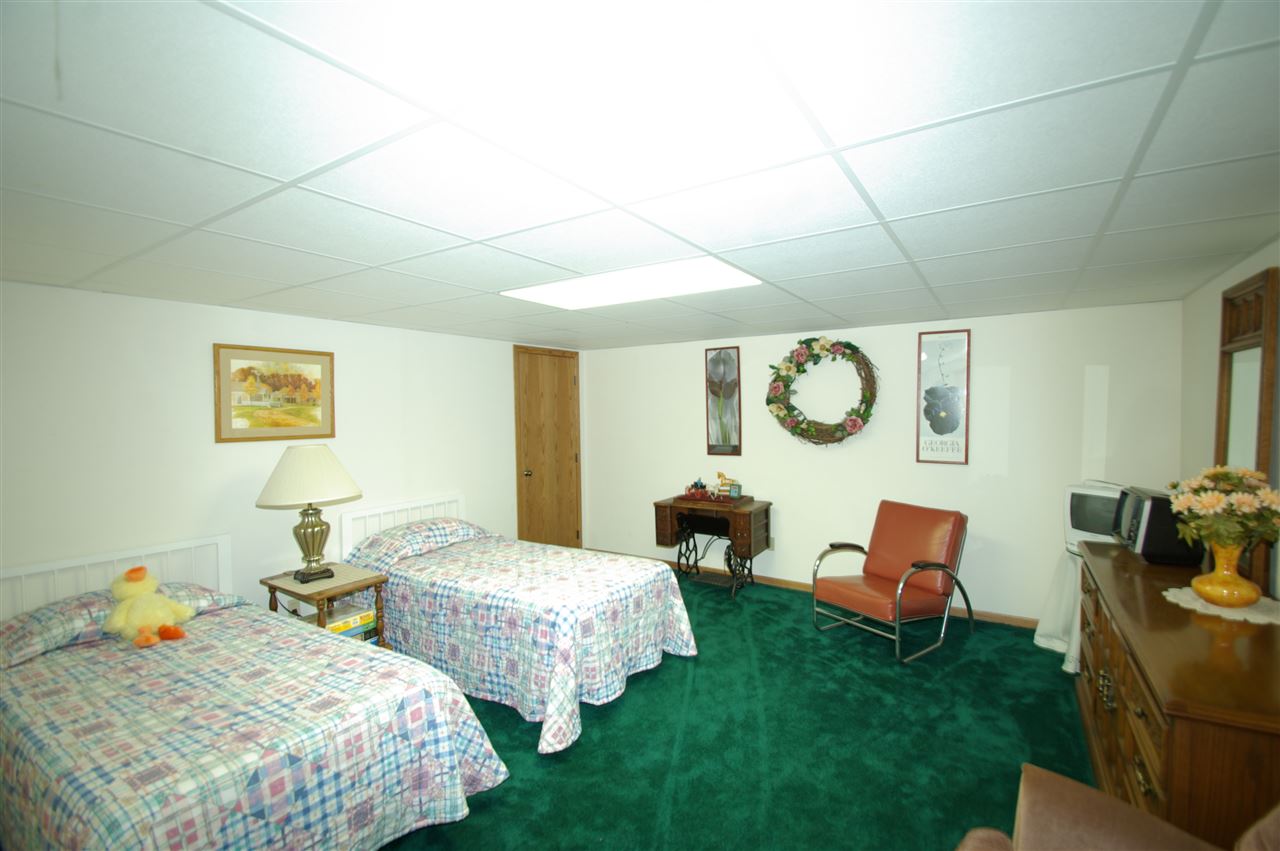 8638 Rote Road Rockford, IL 61107 - Photo 22 of 25 a bedroom with 2 bed and a lamp on table