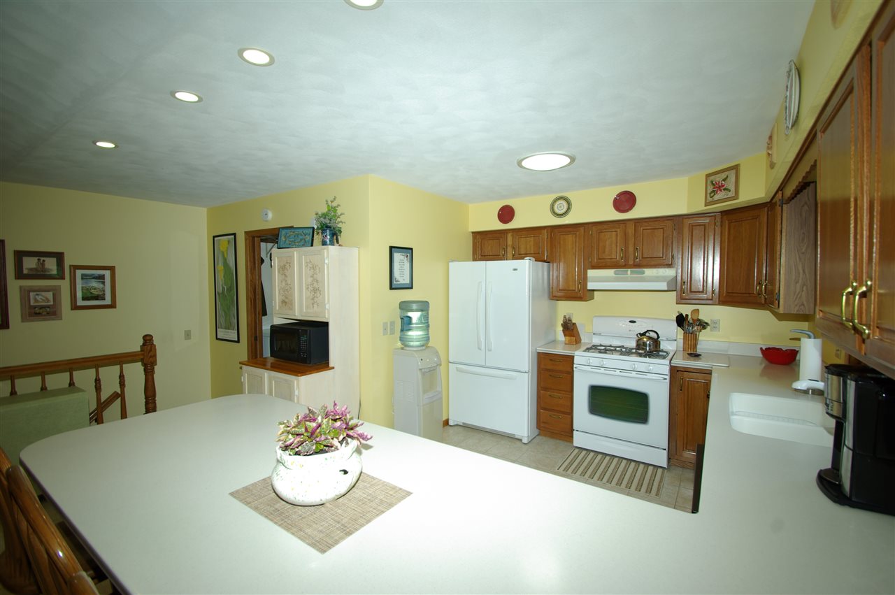 8638 Rote Road Rockford, IL 61107 - Photo 3 of 25 a kitchen with stainless steel appliances kitchen island granite countertop a table chairs stove and refrigerator
