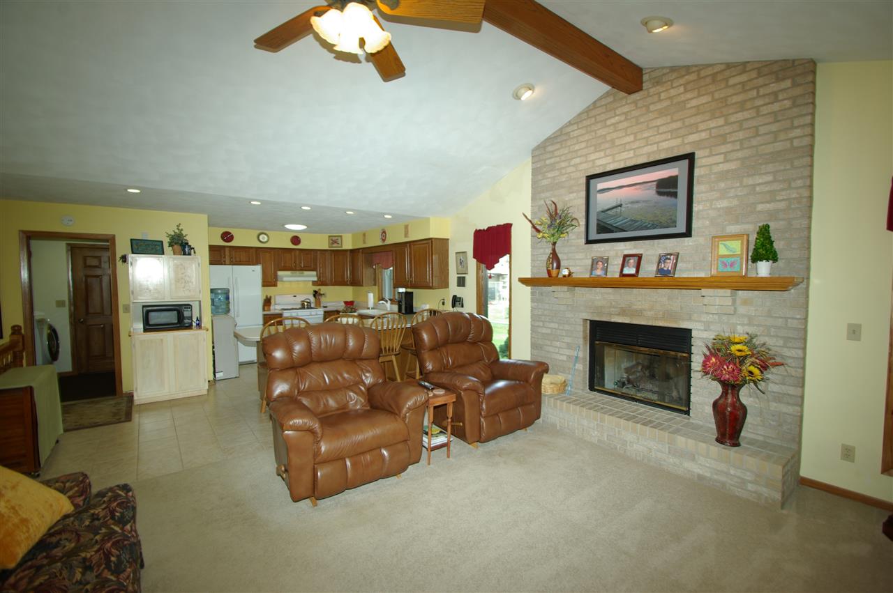 8638 Rote Road Rockford, IL 61107 - Photo 7 of 25 a living room with furniture a fireplace and kitchen view