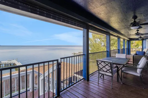 a balcony with wooden floor stairs and furniture