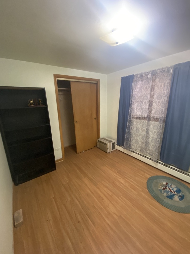 8530 South Carpenter Street, Unit 1 Chicago, IL 60620 - Photo 5 of 10 an empty room with wooden floor and window