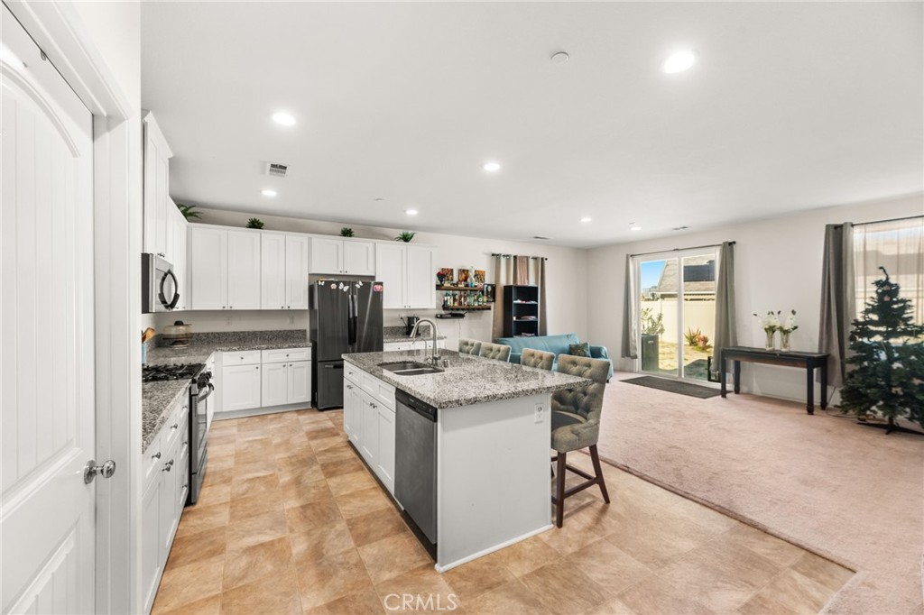 468 Bristolwood Road Hemet, CA 92543 - Photo 11 of 55 a kitchen with stainless steel appliances kitchen island granite countertop a table and chairs in it