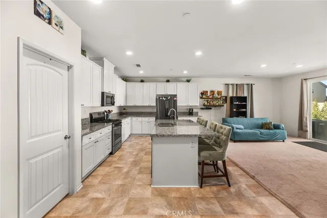 a kitchen with stainless steel appliances granite countertop a sink and a refrigerator