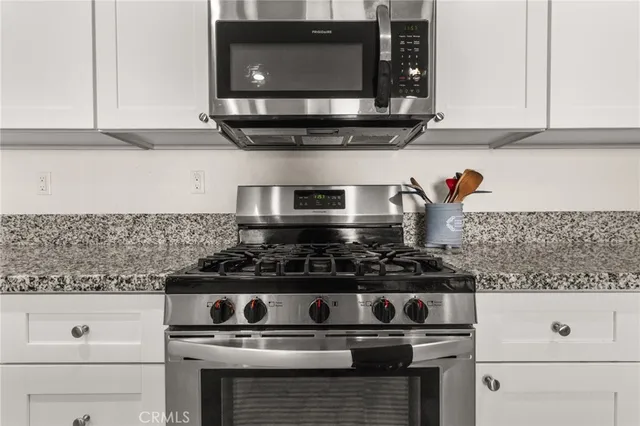 a kitchen with refrigerator and chairs
