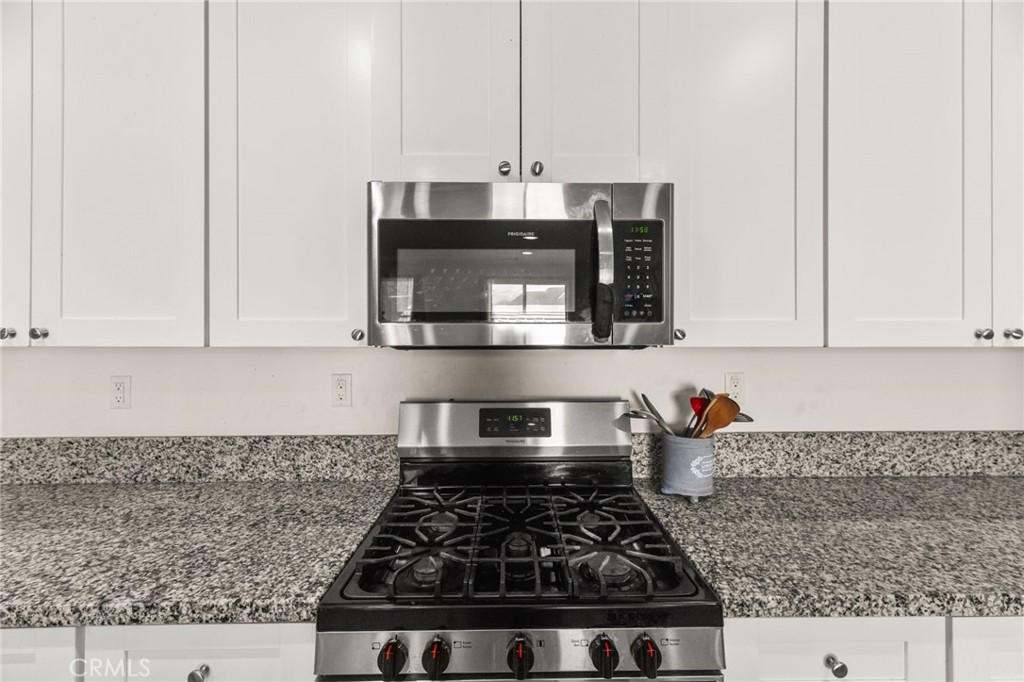 468 Bristolwood Road Hemet, CA 92543 - Photo 16 of 55 a kitchen with stainless steel appliances granite countertop a stove a sink and a microwave
