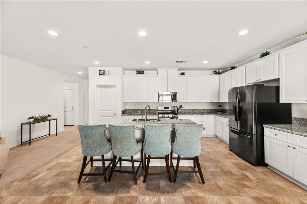 468 Bristolwood Road Hemet, CA 92543 - Photo 17 of 55 a kitchen with refrigerator and chairs