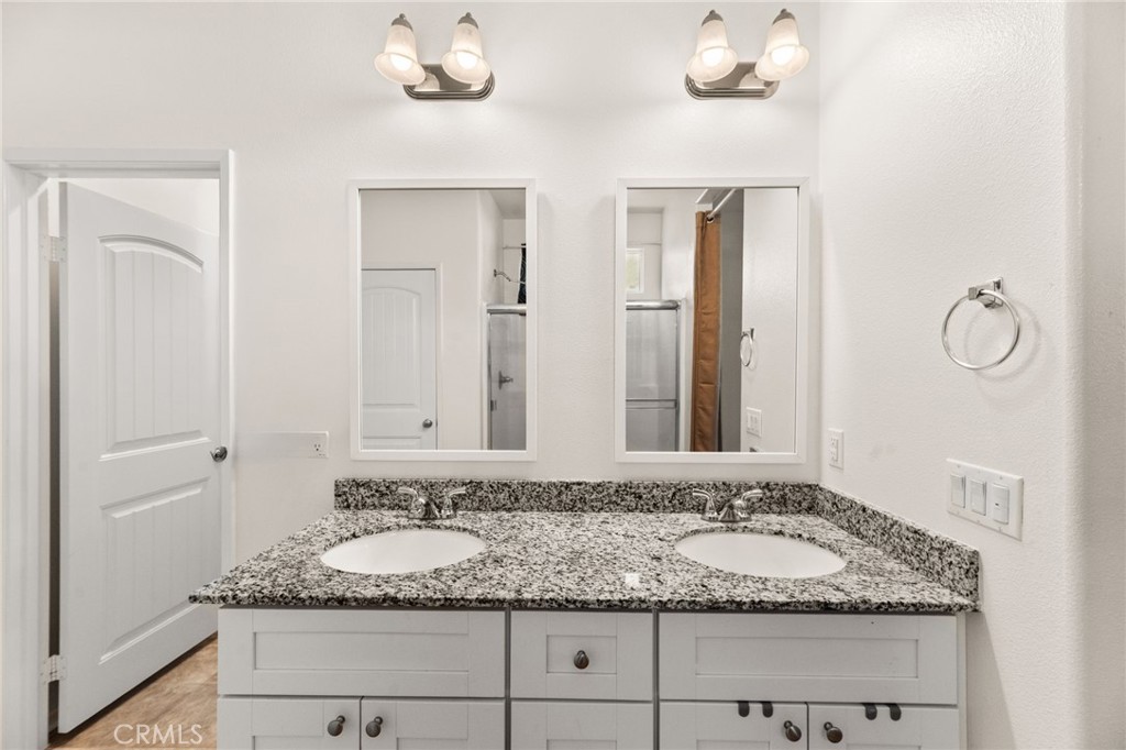 468 Bristolwood Road Hemet, CA 92543 - Photo 32 of 55 a bathroom with a granite countertop sink and a mirror