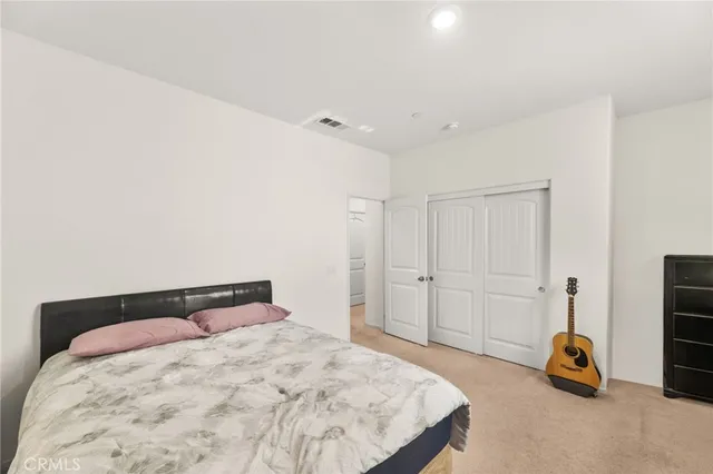 a bedroom with a bed and a potted plant