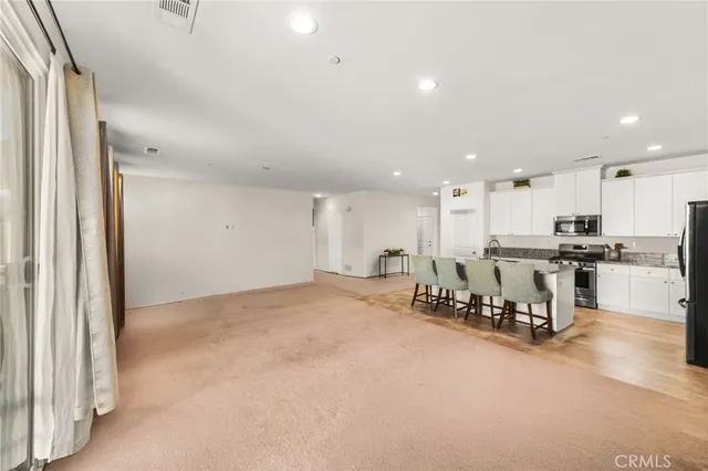 a kitchen with stainless steel appliances kitchen island granite countertop a table and chairs in it