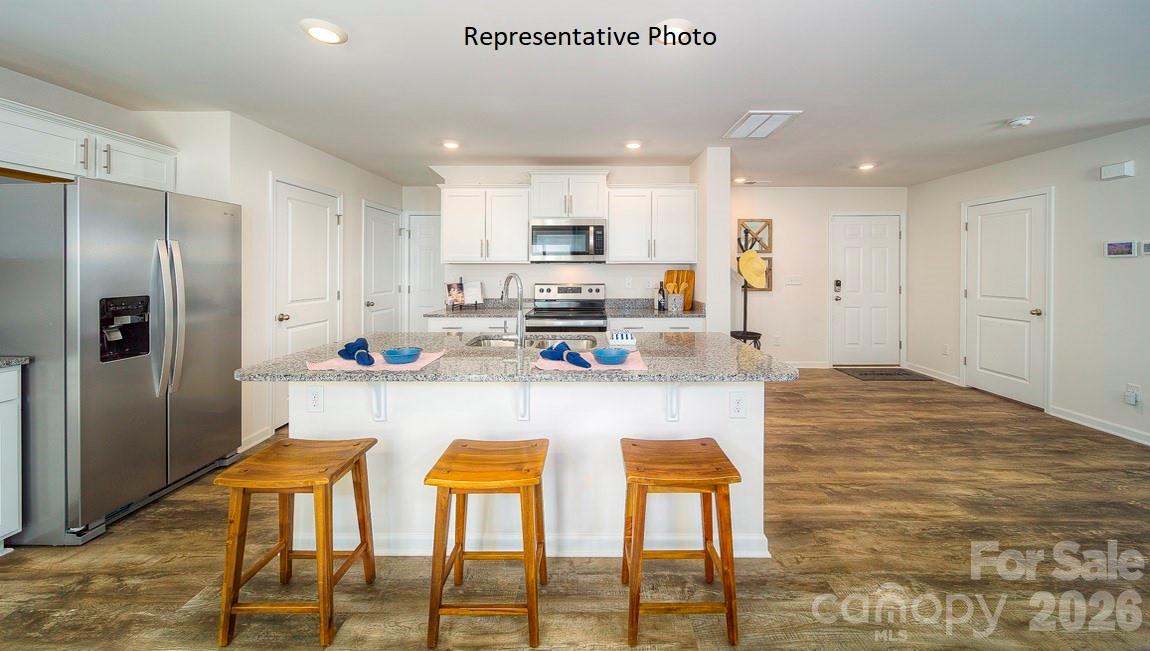 1371 Mammoth Road Hickory, NC 28602 - Photo 5 of 34 a kitchen with stainless steel appliances kitchen island granite countertop a kitchen island and chairs in it