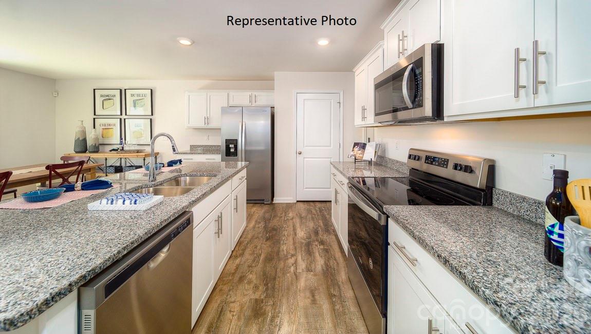 1371 Mammoth Road Hickory, NC 28602 - Photo 6 of 34 a kitchen with stainless steel appliances granite countertop a sink a stove top oven a refrigerator a counter space and cabinets