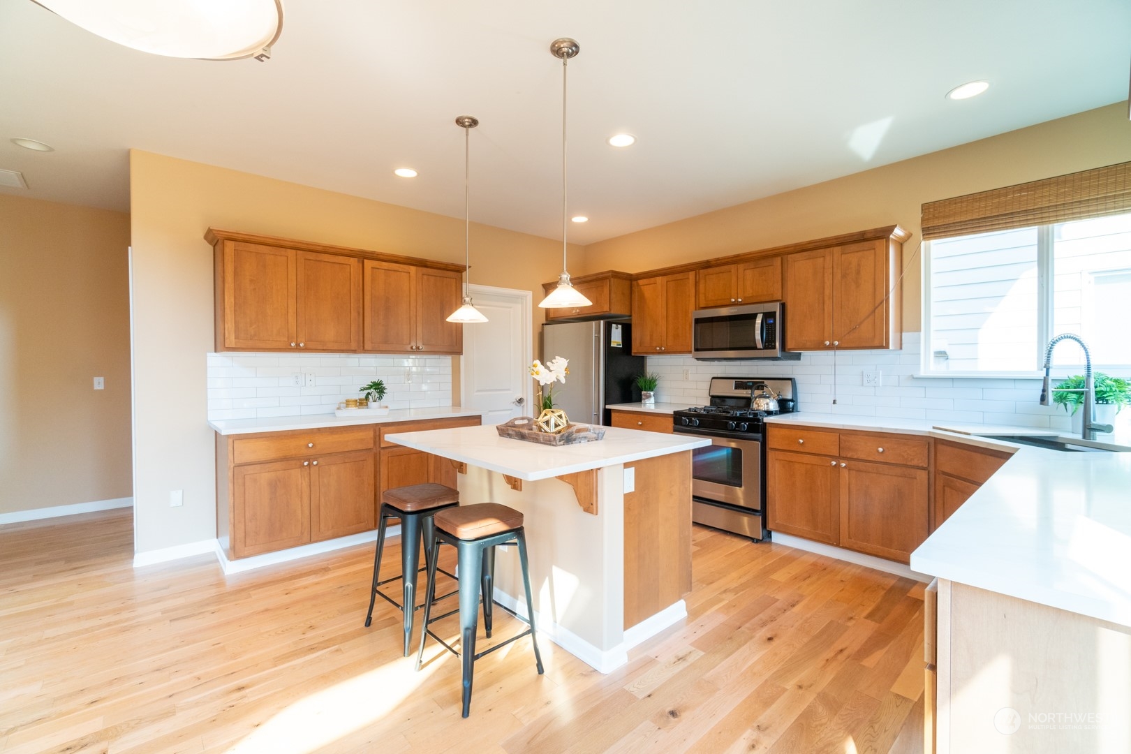 23911 22nd Avenue West Bothell, WA 98021 - Photo 11 of 27 a large kitchen with kitchen island a stove a sink a dining table and chairs