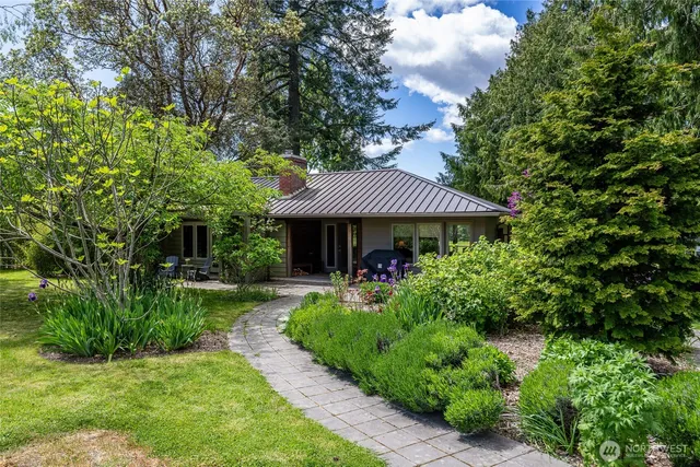 a view of a house with a yard and potted plants