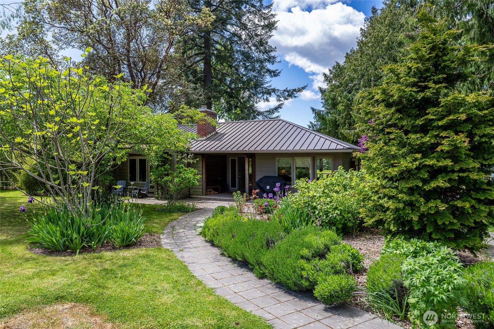 a view of a house with a yard and potted plants