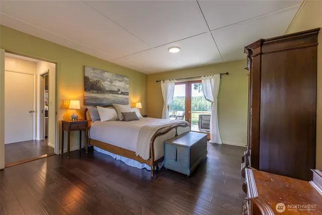 a bedroom with a bed wooden floor and window