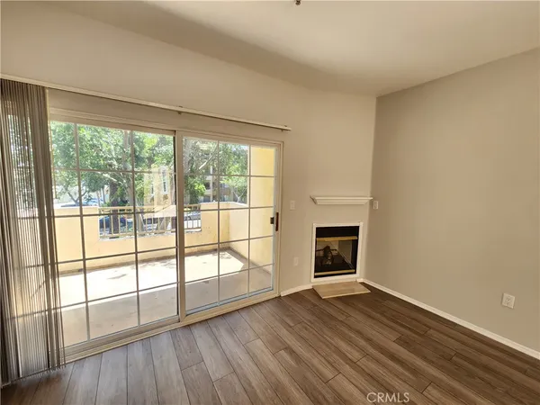 wooden floor fireplace and windows in an empty room