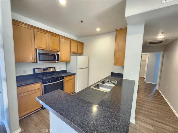 a kitchen with granite countertop stainless steel appliances and wooden cabinets