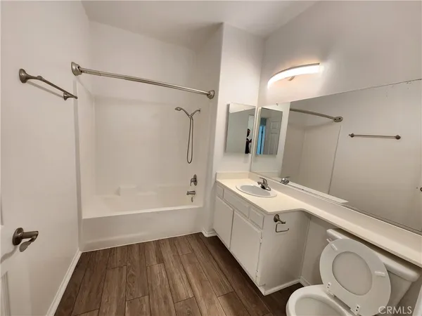 a bathroom with a sink a toilet a mirror and shower