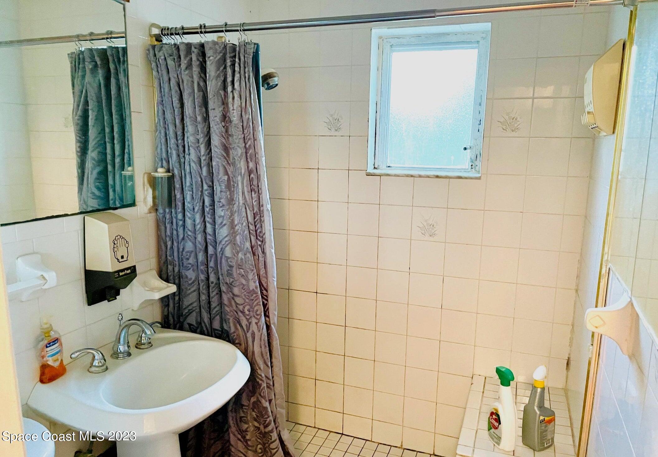 245 Richards Road Melbourne Beach, FL 32951 - Photo 7 of 18 a bathroom with a shower curtain and a sink