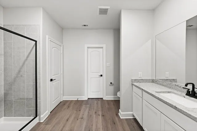 a bathroom with a granite countertop sink toilet and shower