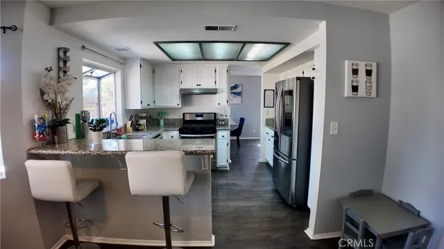 a kitchen with stainless steel appliances granite countertop a sink refrigerator and cabinets