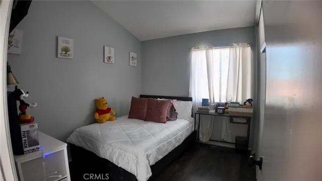 a bedroom with a bed closet and a flat tv screen