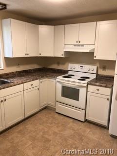 2808 Studley Road Charlotte, NC 28212 - Photo 6 of 6 a kitchen with granite countertop white cabinets and white appliances