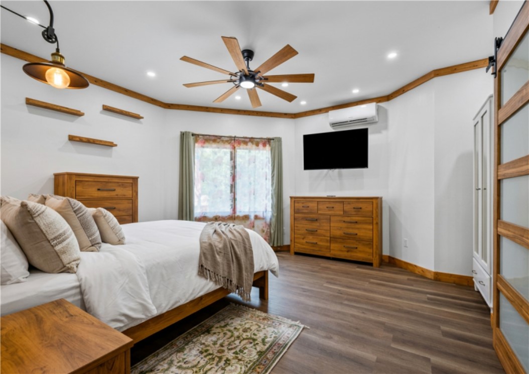 183 Little Eastatoee Road Sunset, SC 29685 - Photo 39 of 50 A well-lit bedroom offers rich wood trim and durable flooring.