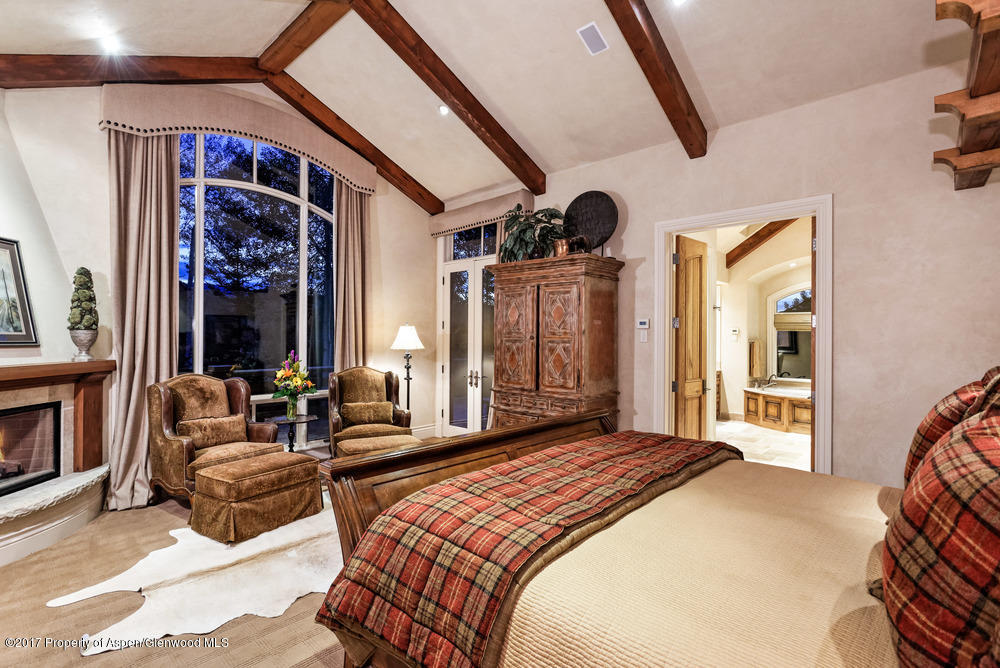 80 Spruce Ridge Lane Snowmass Village, CO 81615 - Photo 18 of 40 a bedroom with a bed and a large mirror next to a window