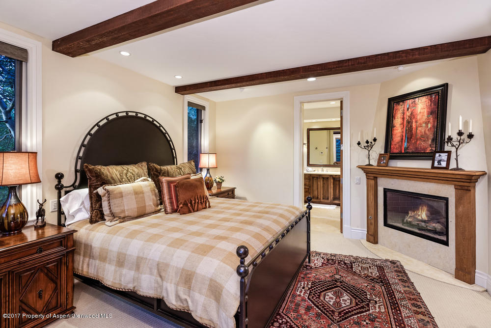 80 Spruce Ridge Lane Snowmass Village, CO 81615 - Photo 25 of 40 a bed room with a bed and a fireplace