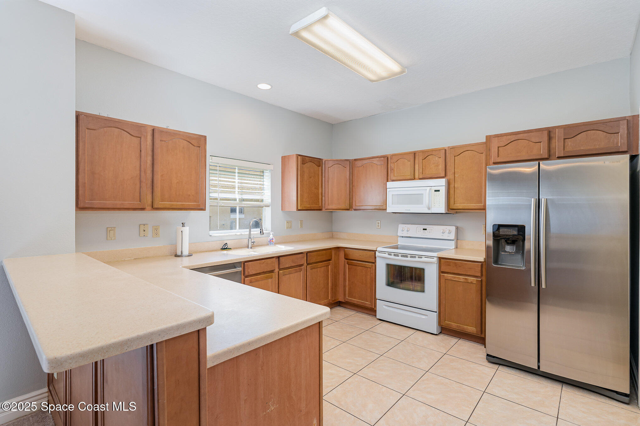 609 Cedar Side Circle Northeast Palm Bay, FL 32905 - Photo 7 of 19 a kitchen with a sink a stove and refrigerator